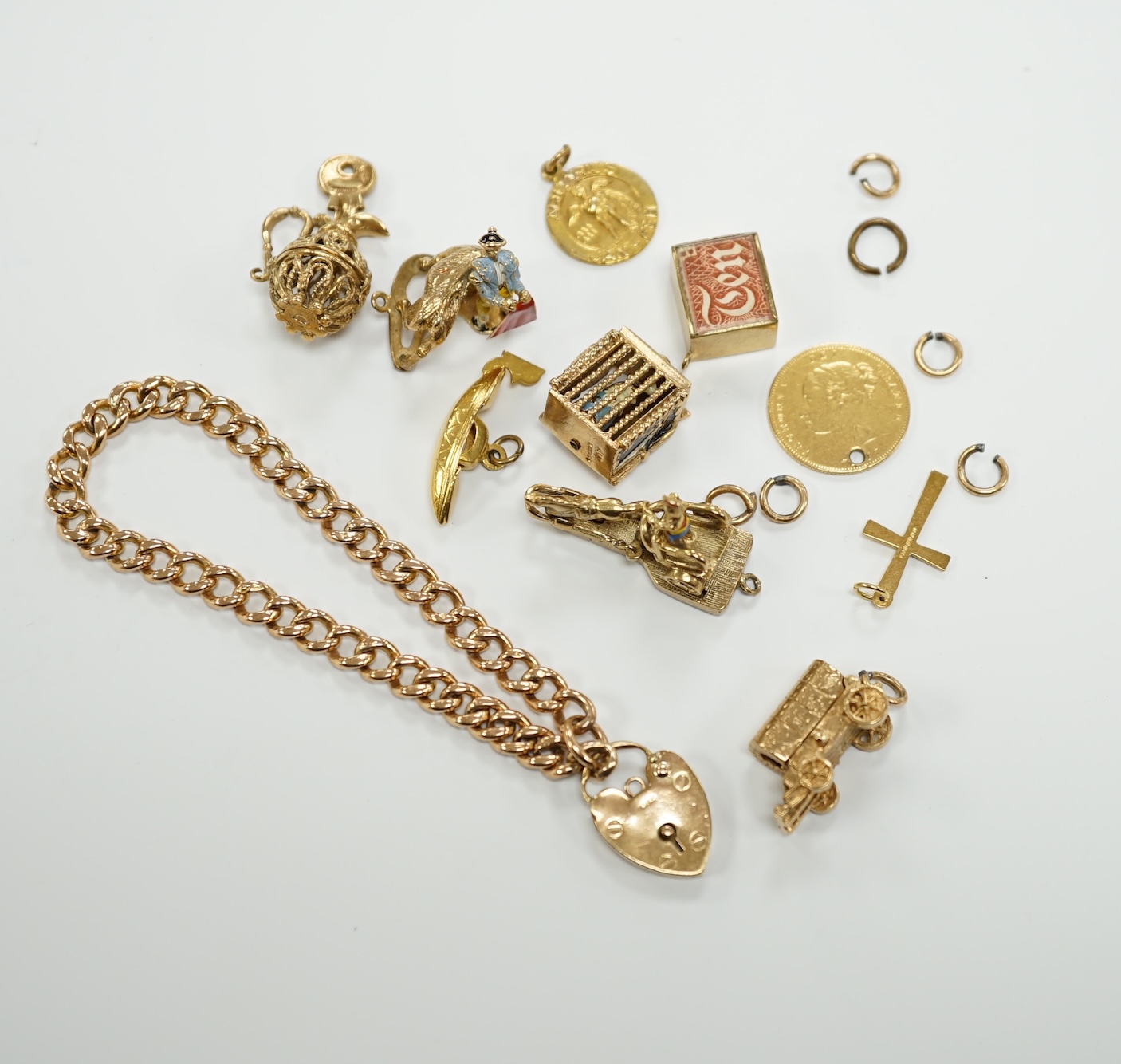 A 9ct gold curb link bracelet and eleven assorted mainly 9ct gold loose charms
